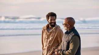 Two men talking on the beach